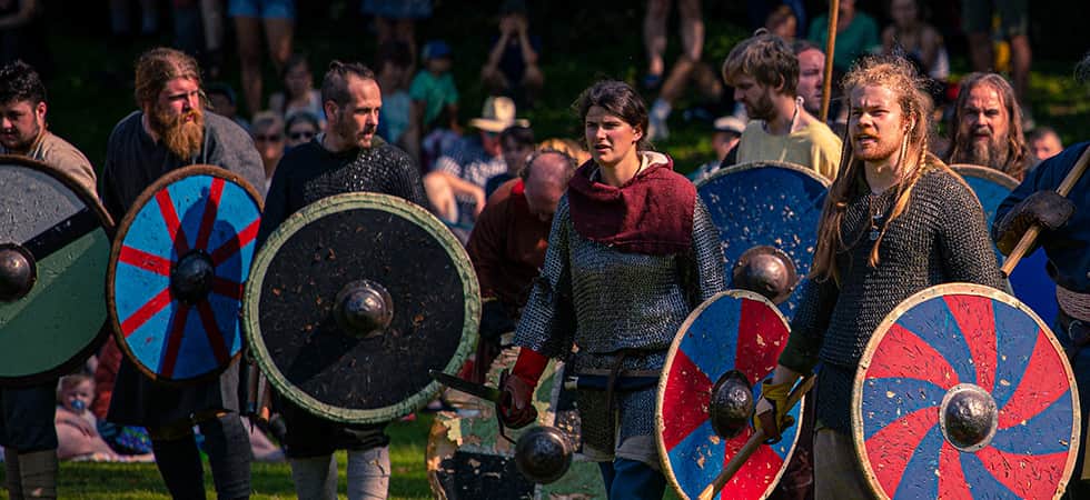This image shows a group of fierce warriors advancing on their enemy branding weapons and wearing chainmail armour